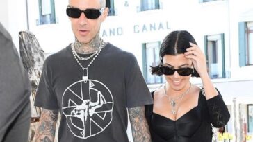 Kourtney Kardashian and Travis Barker pose in bed with matching face masks