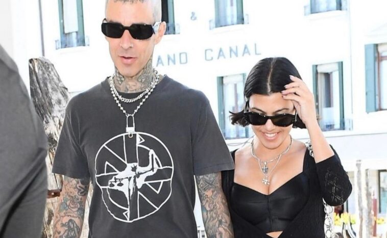 Kourtney Kardashian and Travis Barker pose in bed with matching face masks
