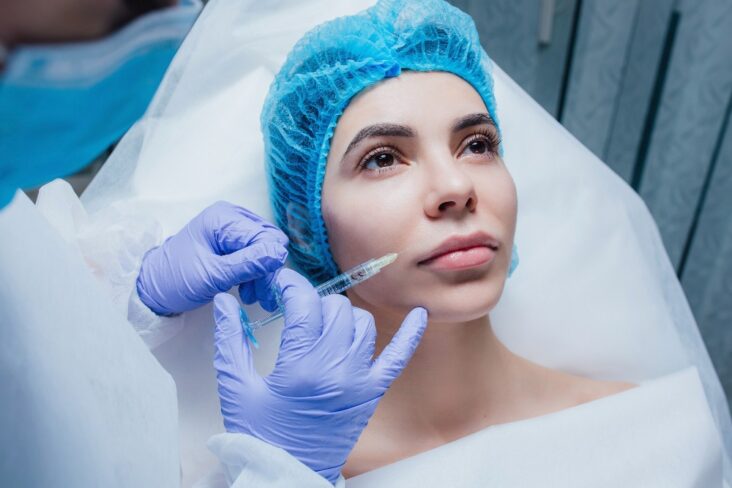 woman getting cosmetic injection botox lip closeup woman beauty salon plastic surgery clinic