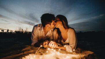 Man And Woman Kissing On Brown Sand During Night Time