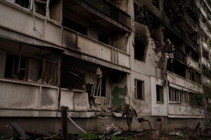 A Ukrainian serviceman inspects a severely damaged apartment building after a Russian bombardment in Kharkiv Ukraine Sunday April 24 2022