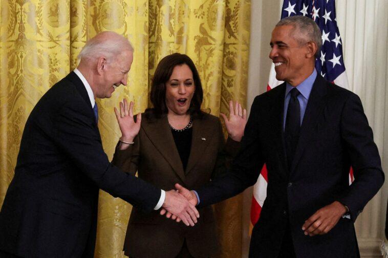 Joe Biden shakes hands with Barack Obama under the gaze of Kamala Harris.
