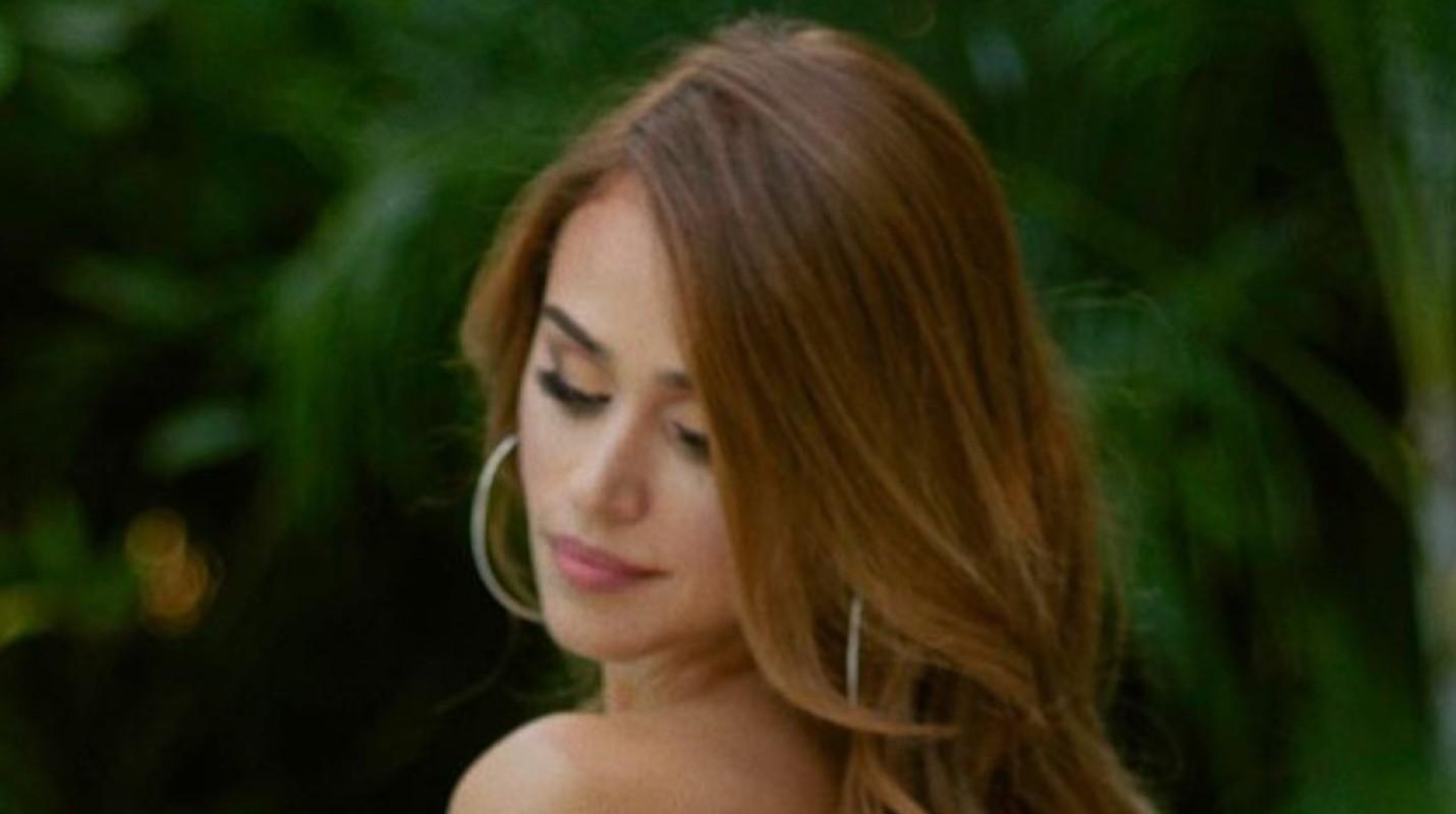 Yanet Garcia poses on her back and shows off her figure in a swimsuit