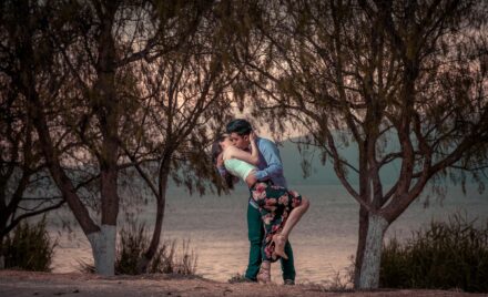 couple kissing in front of trees