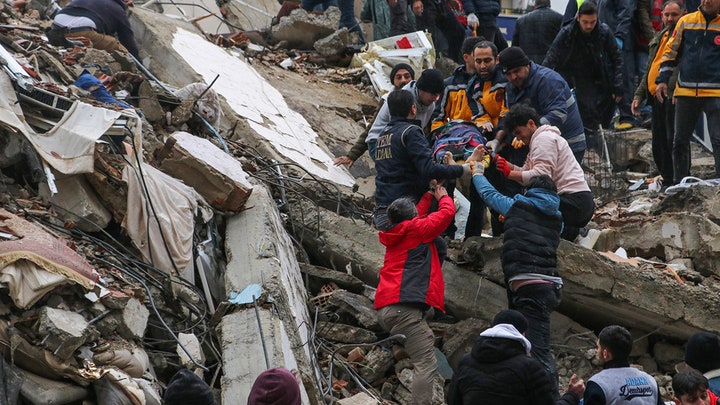 A car is seen under the wreckage of a collapsed building in Azmarin town in Idlib province northern Syria