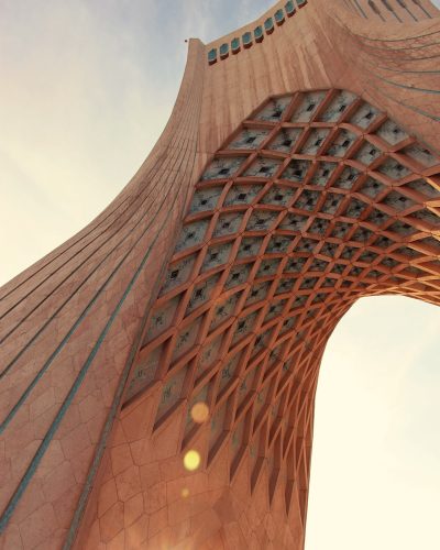 low-angle photography of a brown archway under a calm blue sky