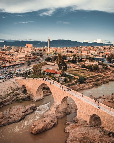 a bridge over a river with a city in the background