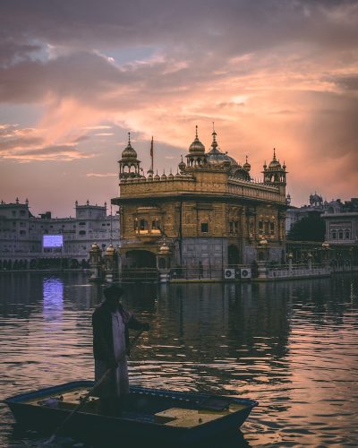 man riding on boat near golden mosque