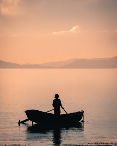 man in boat on lake during daytime