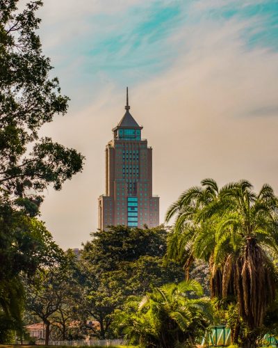 brown concrete building near green trees under blue sky during daytime
